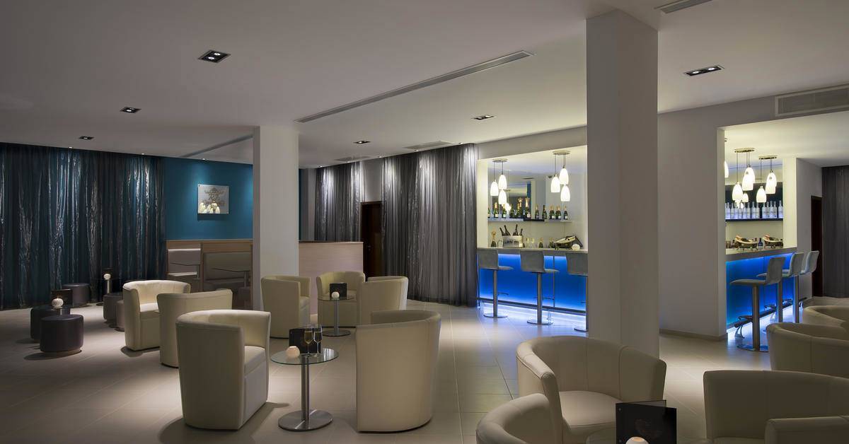 Loungebereich des Melia Dunas Beach Resort & Spa mit weißen Sesseln und einer Bar.