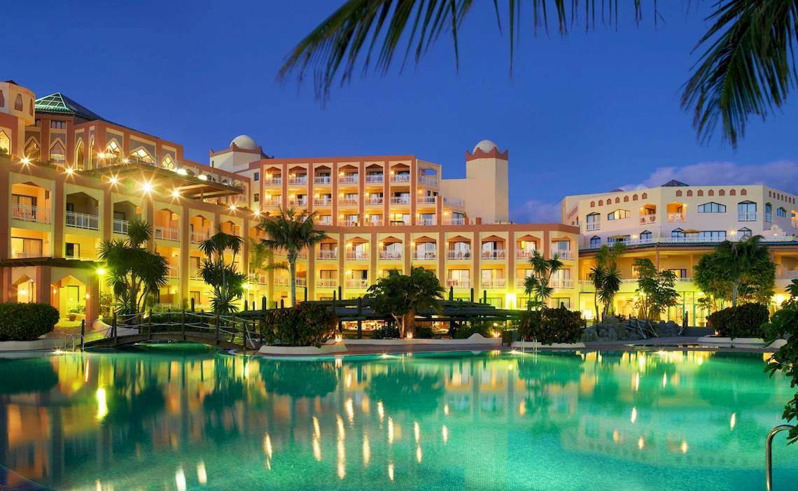 H10 Playa Esmeralda Hotel bei Nacht mit illuminierten Gebäuden und einem Pool im Vordergrund.