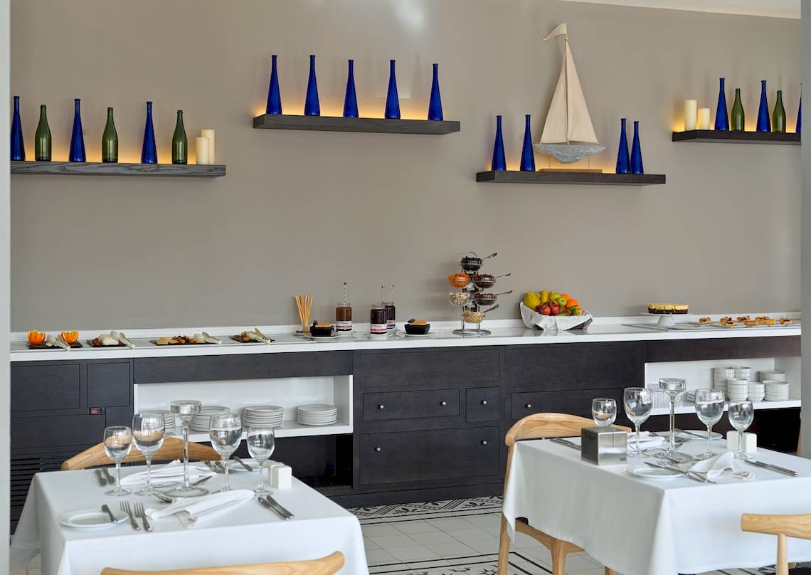 Buffettisch im Restaurant des H10 Playa Esmeralda Hotels mit Früchten und Geschirr.