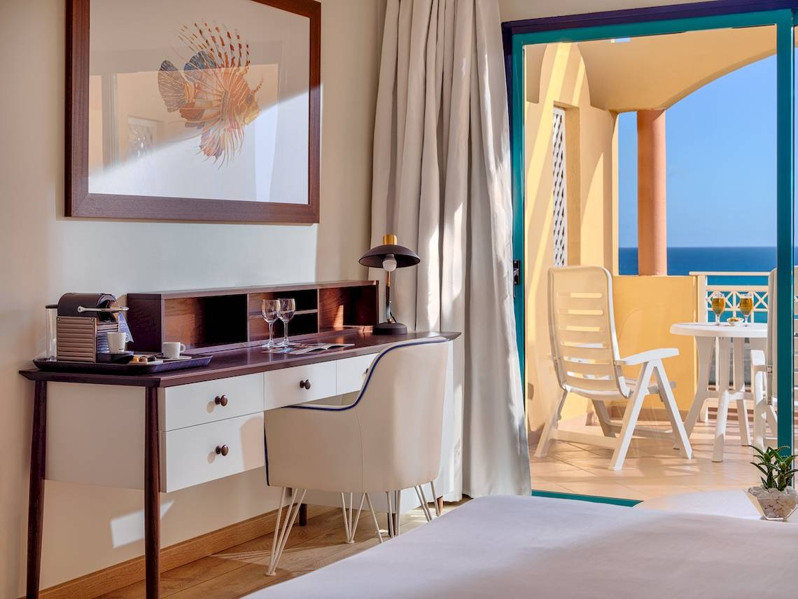 Zimmer im H10 Playa Esmeralda Hotel mit Schreibtisch und Meerblick.