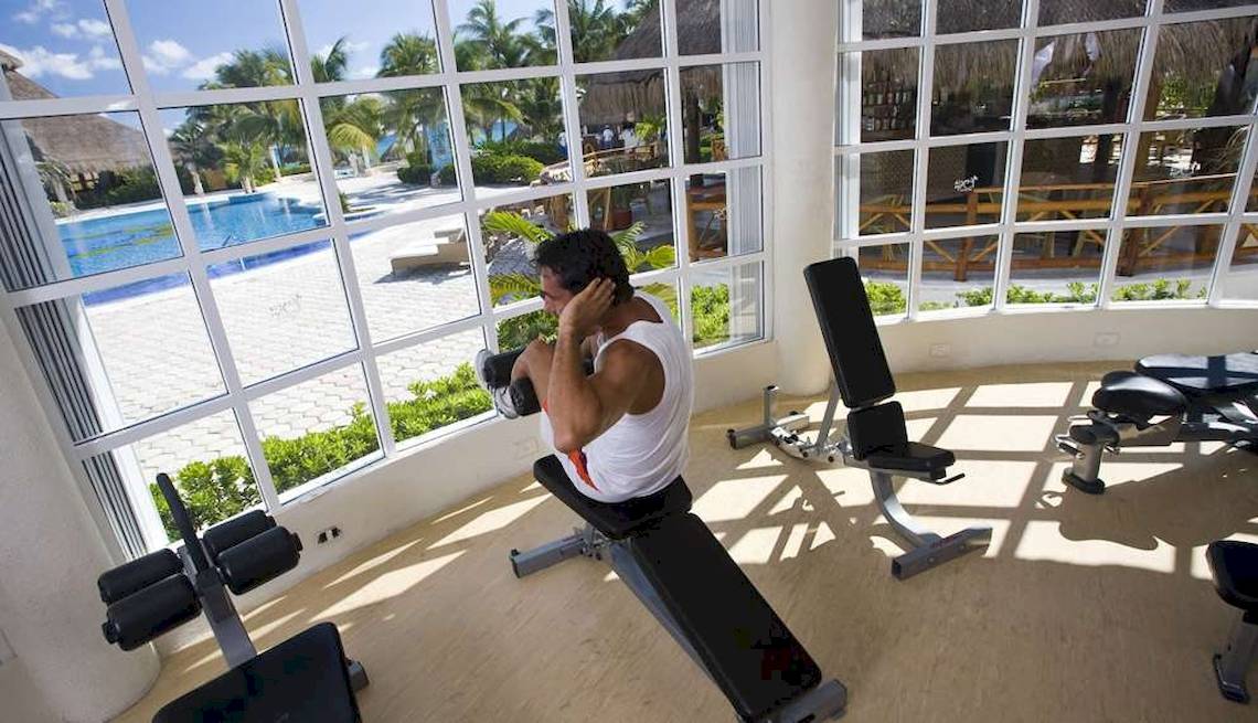 Fitnessstudio im Hotel Catalonia Royal Tulum mit Blick auf den Pool.