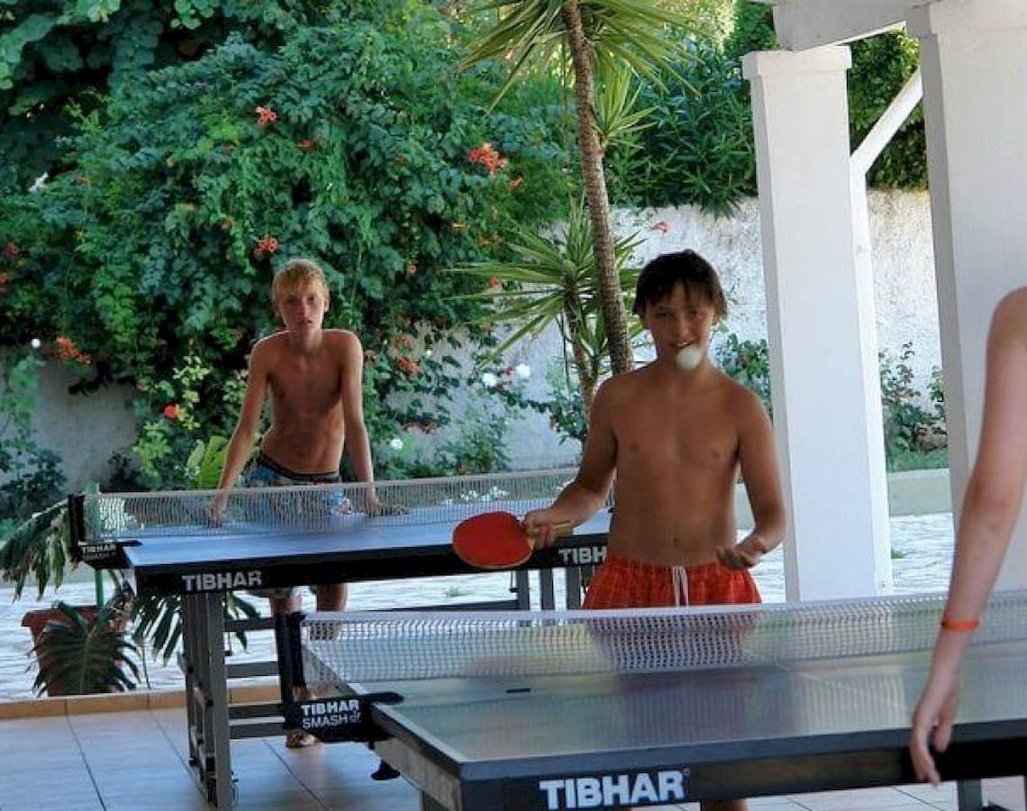 Junge spielen Tischtennis im Freien im Hotel Elea Beach.