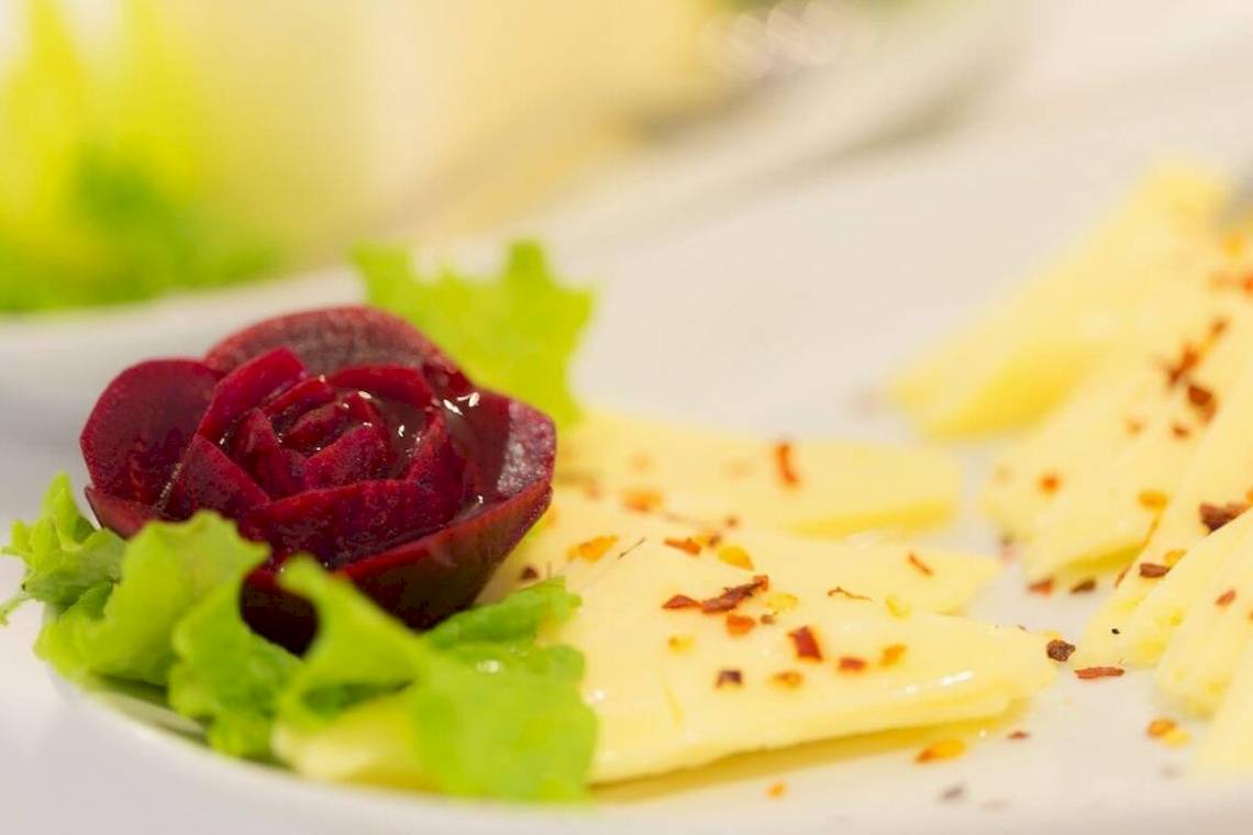 Nahaufnahme eines Gerichts mit roter Rübe und Käse auf einem weißen Teller.