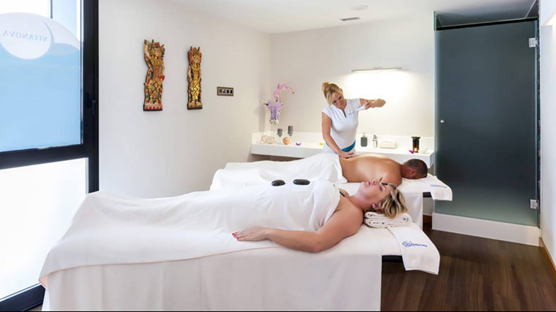 Spa-Behandlung im Hotel Tigotan Lovers & Friends, wo zwei Personen eine Massage auf dem Bett genießen.