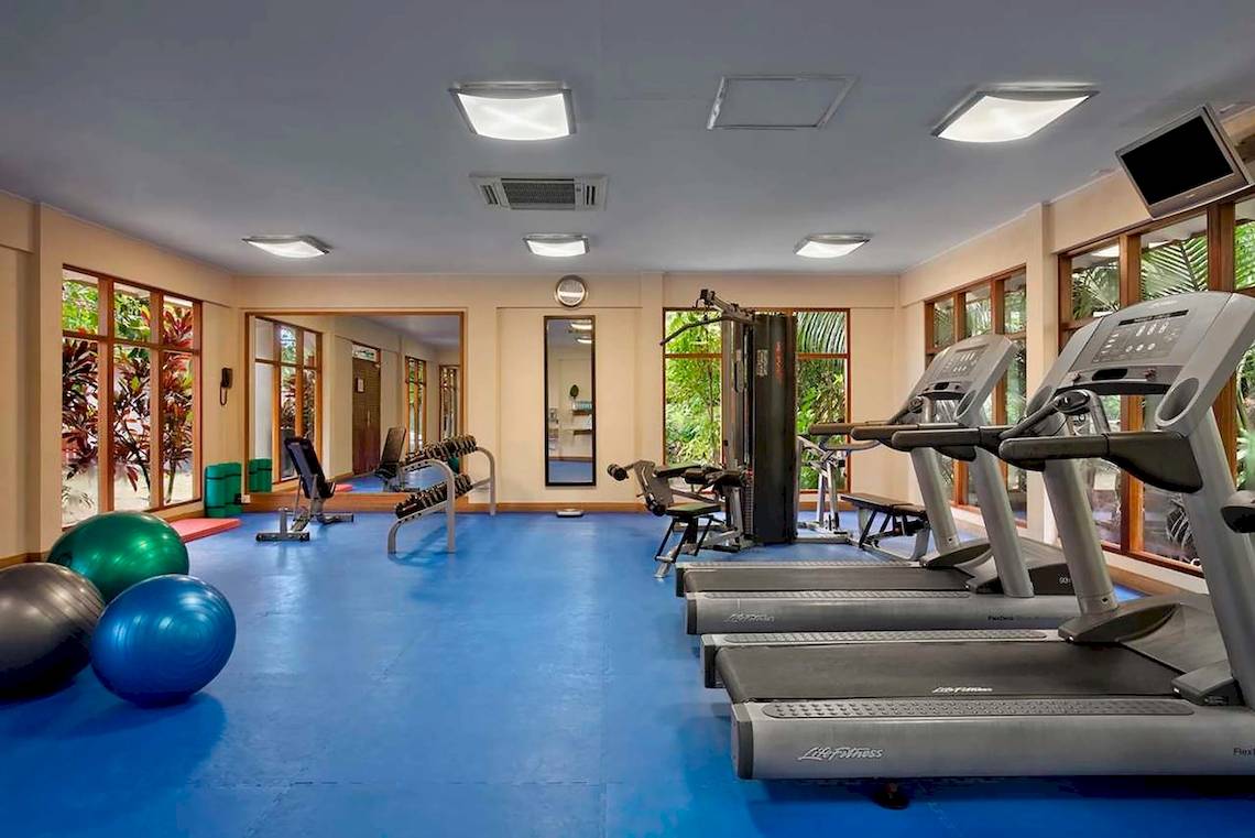 Fitnesscenter im Hilton Seychelles Labriz Resort & Spa mit Laufbändern, Hanteln und Trainingsbällen.
