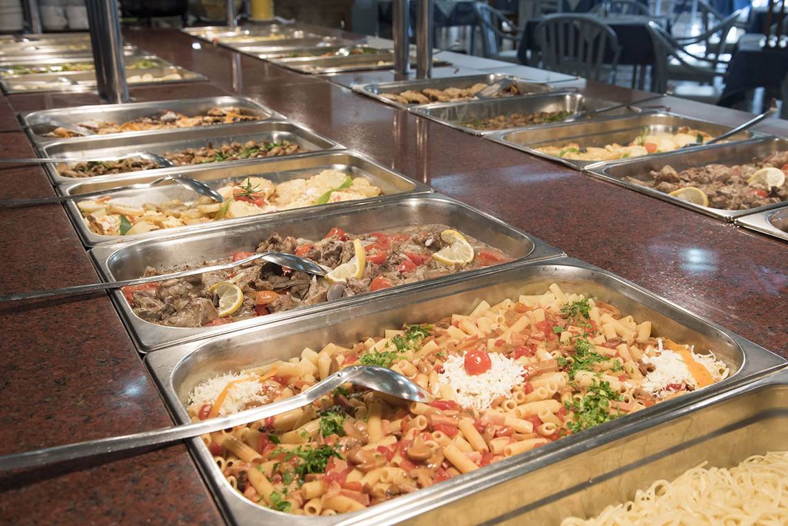 Buffet im Eurovillage Achilleas mit verschiedenen Speisen in Metallschalen.