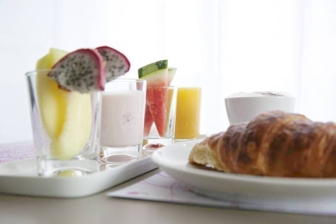 Frühstücksbuffet im Hotel Ku Damm 101 mit Früchten, Säften und Croissants.