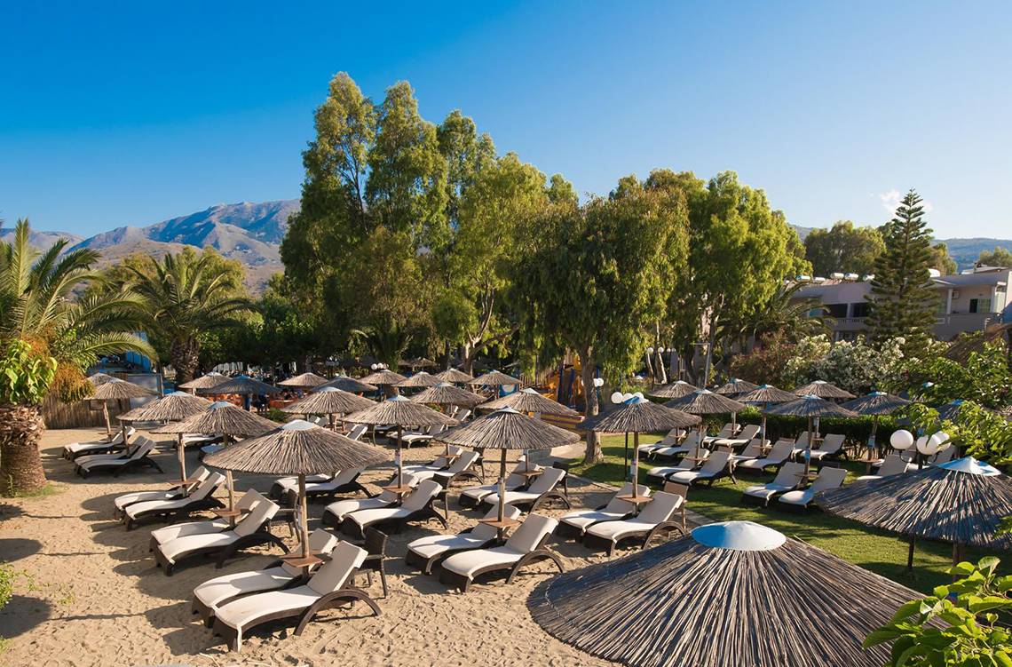 Luftaufnahme des Corissia Princess Hotel Strandes mit vielen Liegen und Sonnenschirmen.