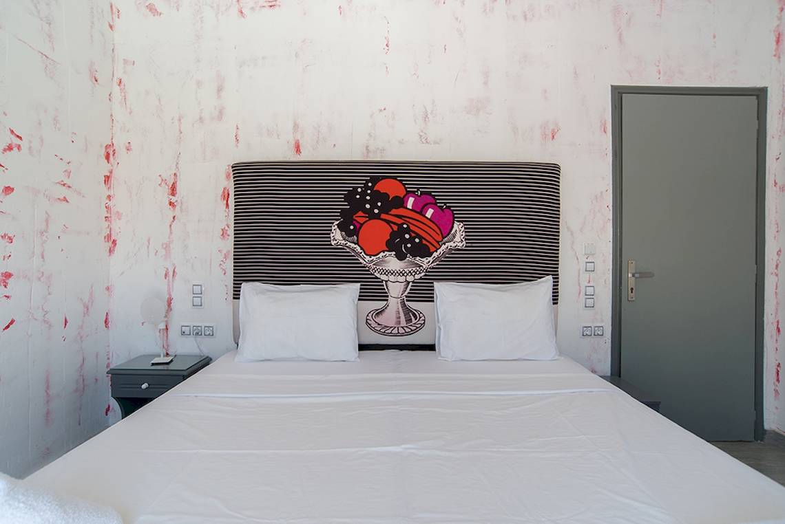 Ein Bett im Zimmer mit einem Wandgemälde einer Obstschale auf dem Kopfteil