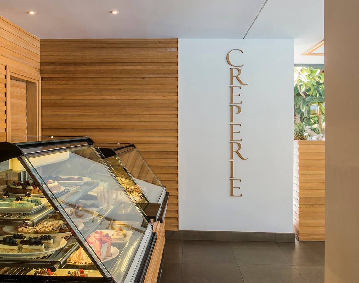 Im Mitsis Grand Hotel Beach zeigt eine Vitrine verschiedene Desserts in einem Café.
