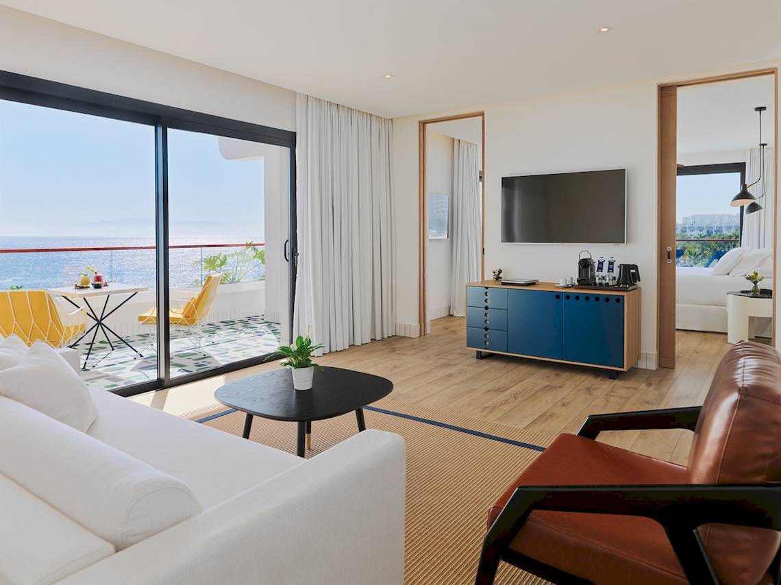 Innenansicht der Suite im H10 Atlantic Sunset Hotel mit Blick auf das Meer, einem modernen Wohnzimmer und einer Terrasse.