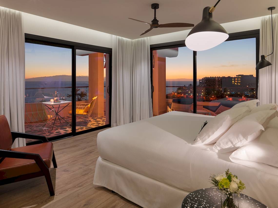 Zimmer im H10 Atlantic Sunset Hotel mit Blick auf das Meer und die Stadt bei Sonnenuntergang.
