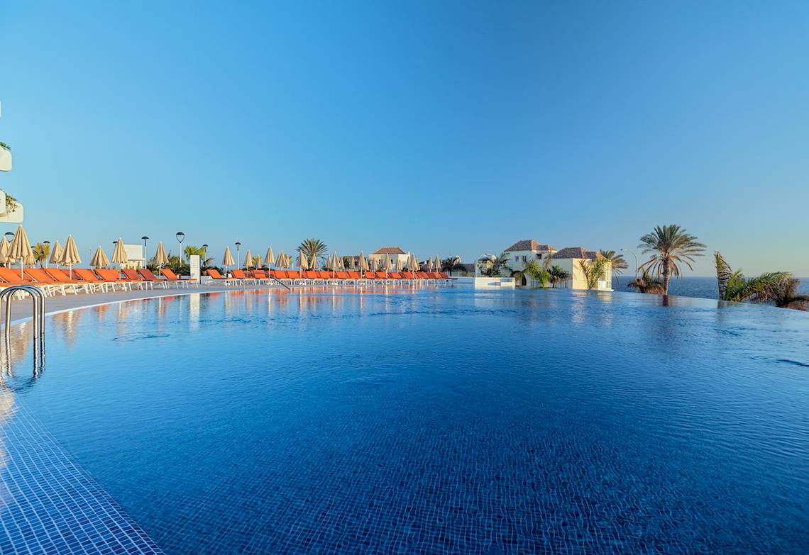 Außenpool des H10 Atlantic Sunset Hotels mit orange Liegestühlen und Palmen