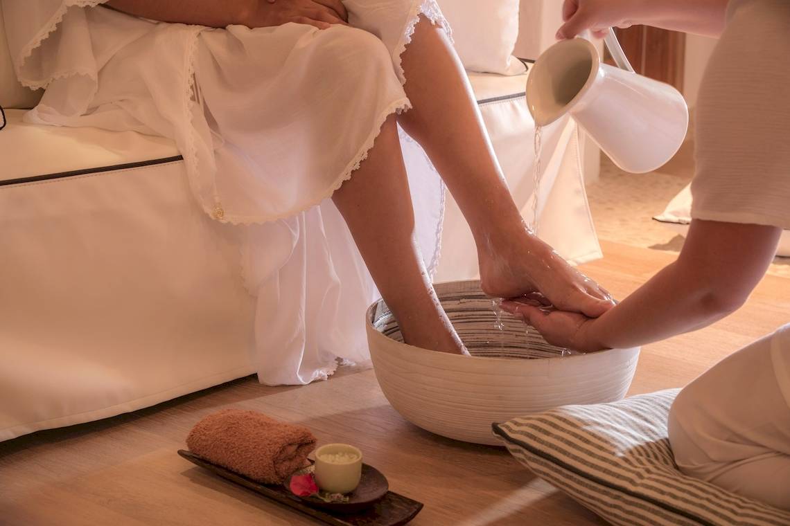 Gast im Hotel Katikies Chromata Santorini genießt eine Fußmassage.