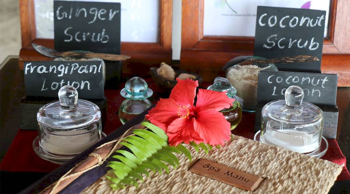 Spa-Tisch im Nova Maldives Hotel mit verschiedenen Produkten und einer roten Blume.
