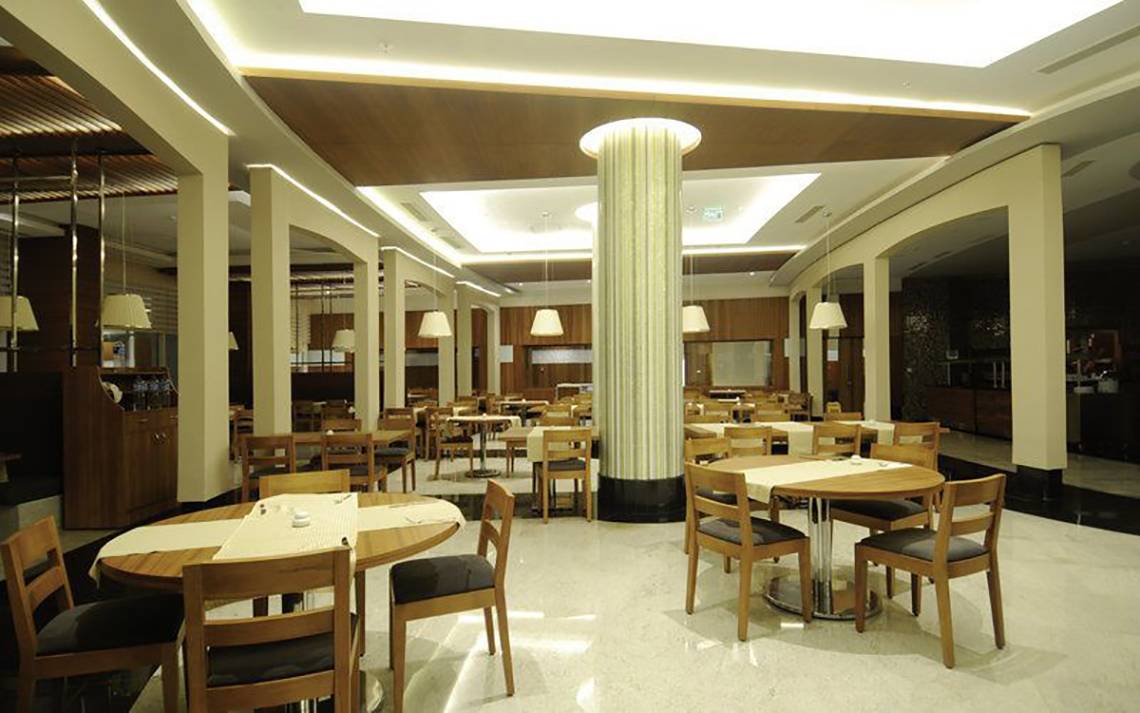Innenbereich des Gold Island Hotels, Restaurant mit runden Tischen und Stühlen.