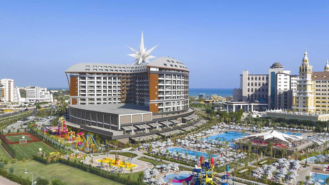 Luftaufnahme des Royal Seginus Hotels mit Swimmingpools und Spielplatz im Vordergrund.