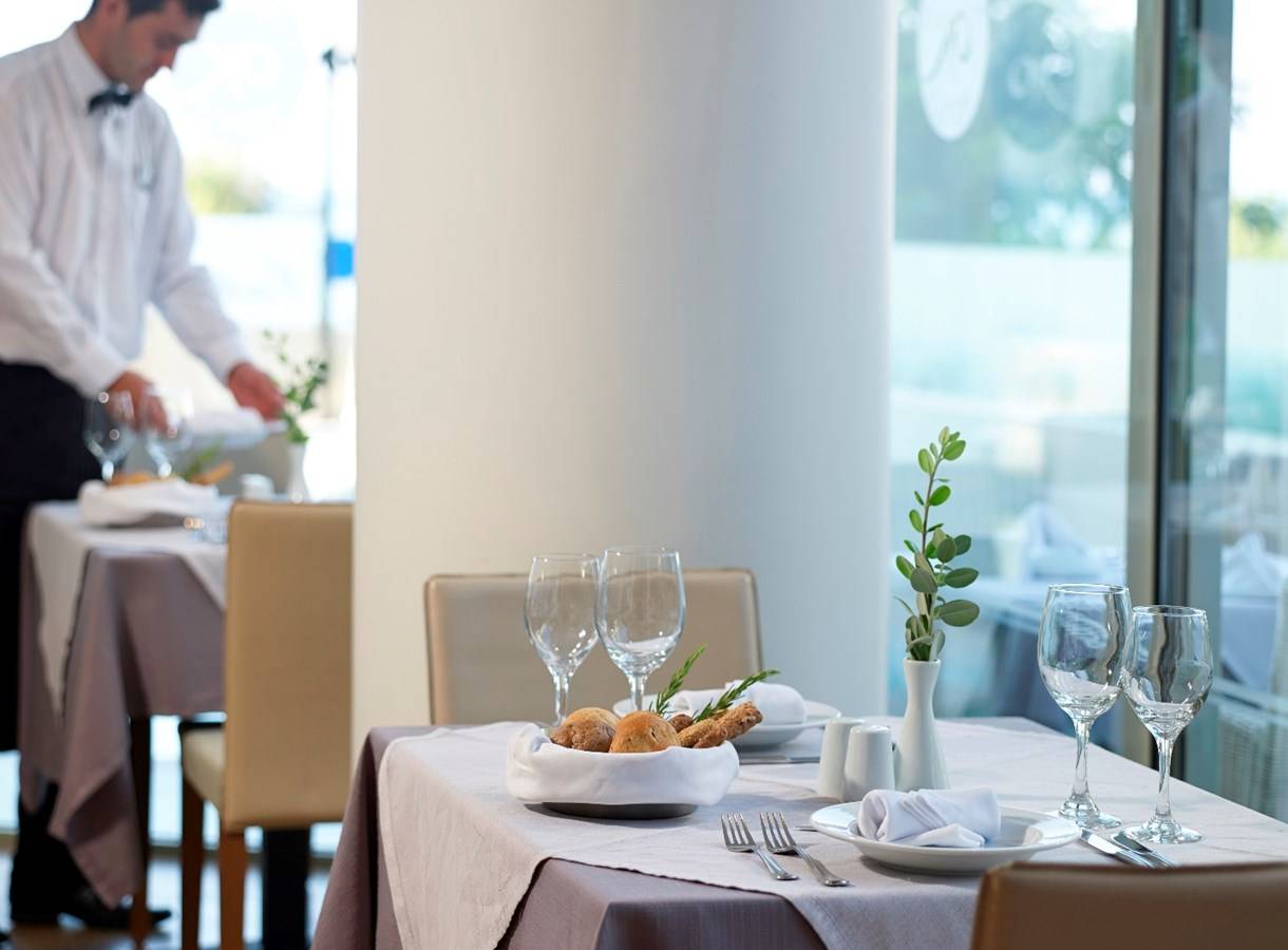Kriti Beach Hotel Restaurant Tisch mit Gläsern, Besteck und Pflanzendekor