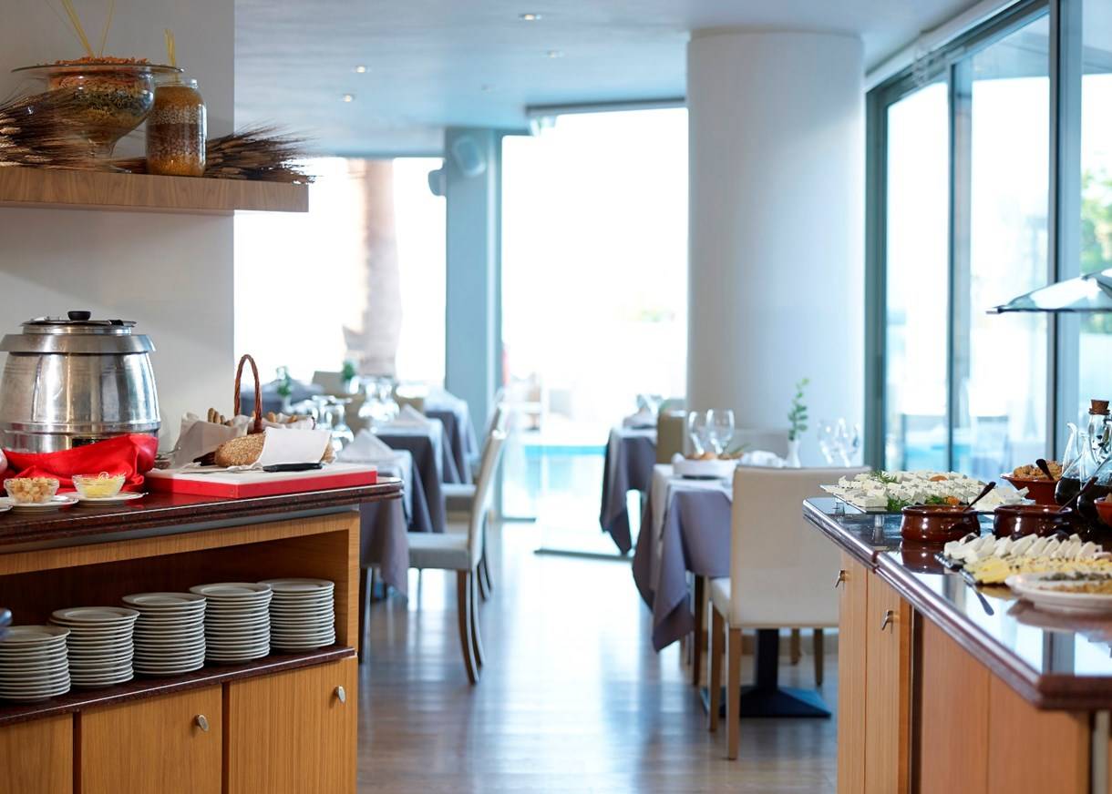 Buffetbereich im Kriti Beach Hotel mit verschiedenen Gerichten und Tischen.