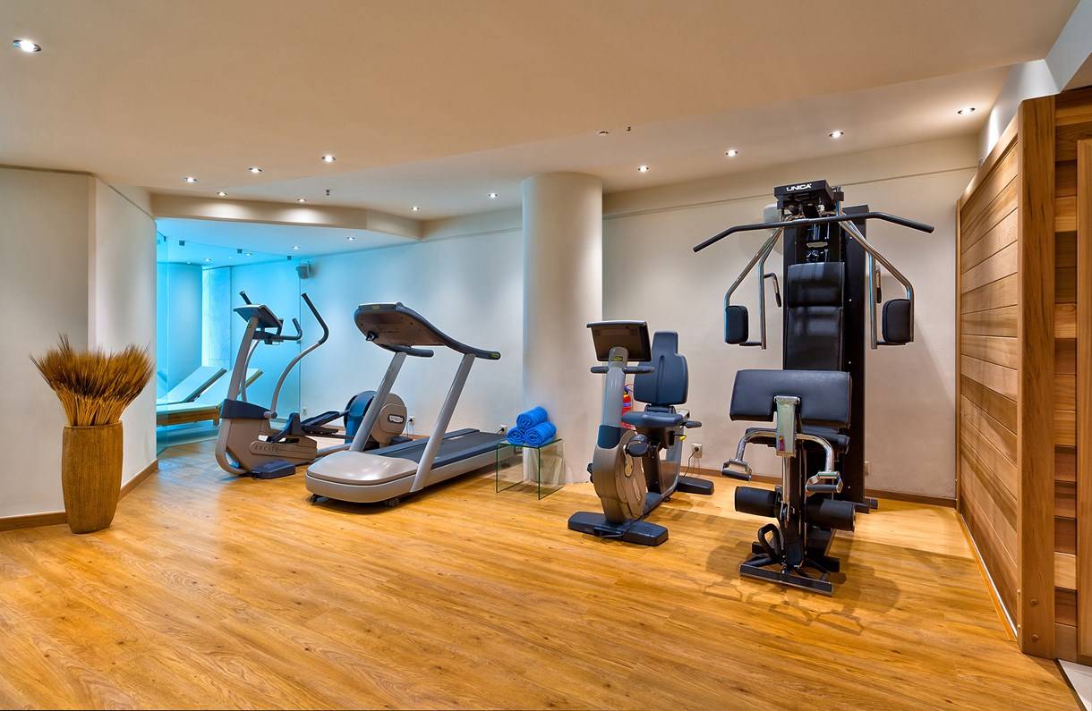 Fitnessraum im Kriti Beach Hotel mit Laufband, Rudergerät und Liegebank.