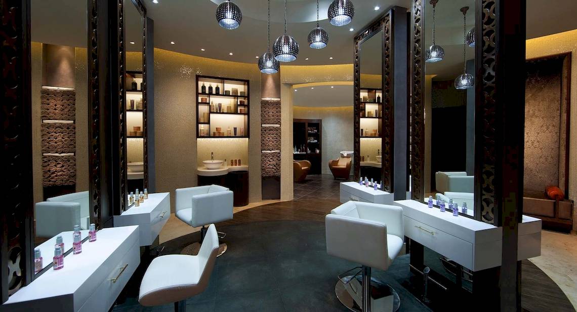 Friseursalon im Anantara Eastern Mangroves Abu Dhabi Hotel mit weißen Stühlen und Spiegeln