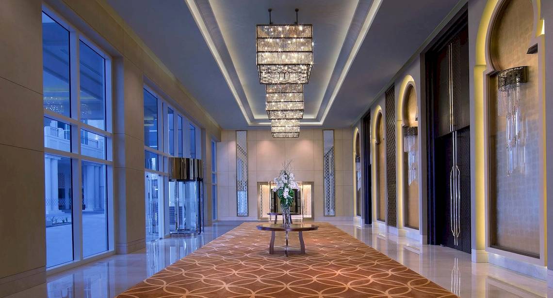 Die Lobby des Anantara Eastern Mangroves Abu Dhabi Hotels mit langen Fluren und großen Fenstern.
