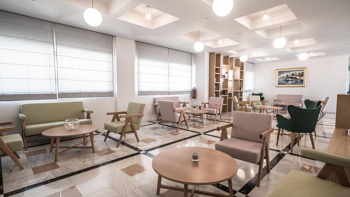 Lobby des Adele Beach Hotels mit Sitzgelegenheiten und Tischen.