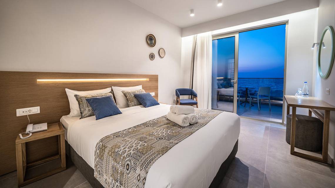Hotelzimmer im Adele Beach Hotel mit großem Bett und Meerblick.