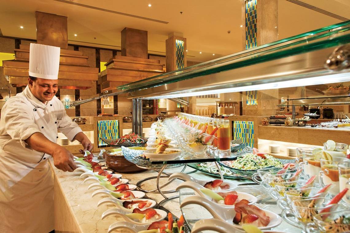 Ein Koch im Mövenpick Resort & Spa El Gouna bereitet ein Buffet zu.
