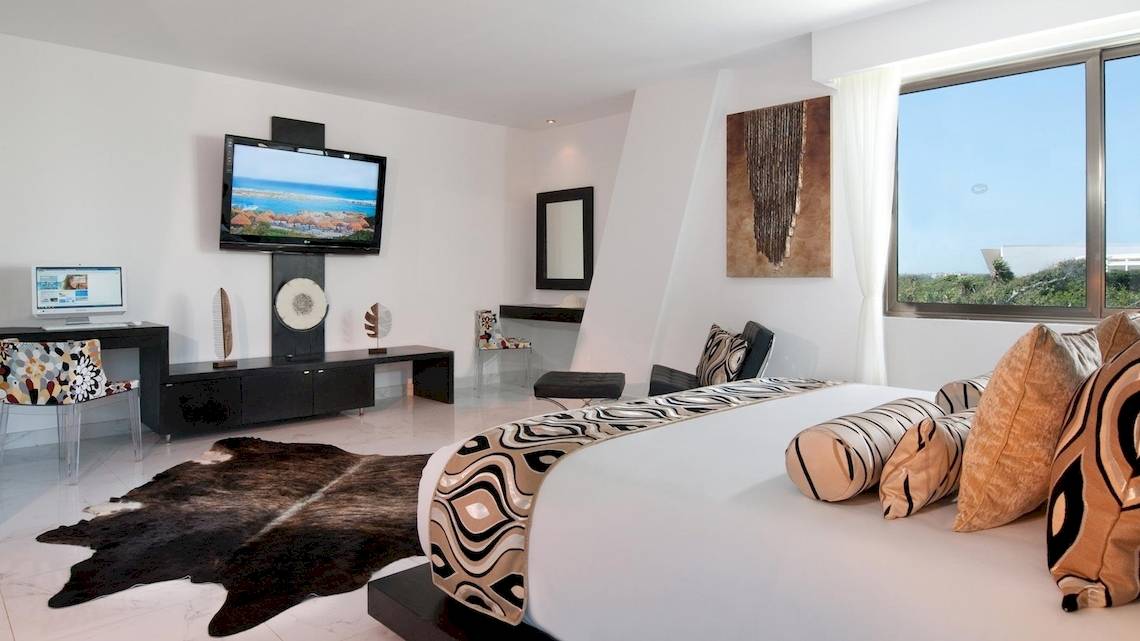 Schlafzimmer im Grand Sirenis Riviera Maya Resort & Spa mit Fernseher, Schreibtisch, Bett und Fenster