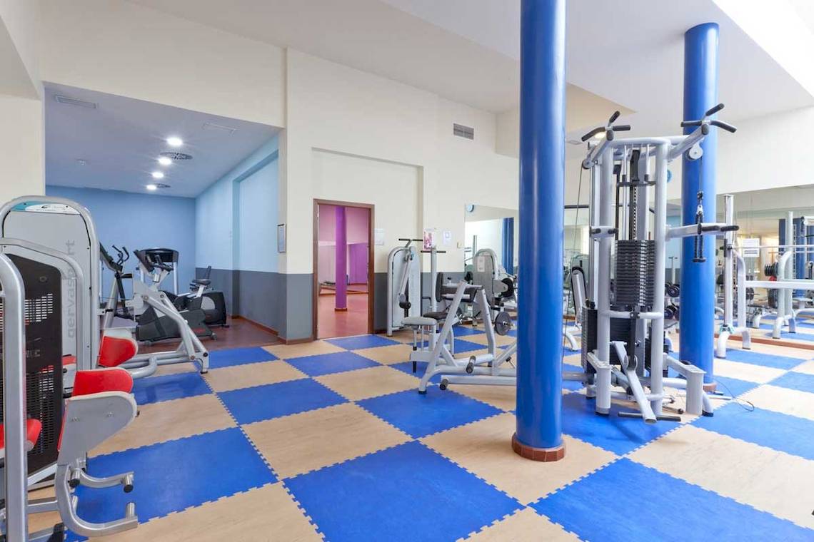 Fitnessstudio im Roca Nivaria Gran Hotel mit blauen und weißen Bodenfliesen und diversen Fitnessgeräten.