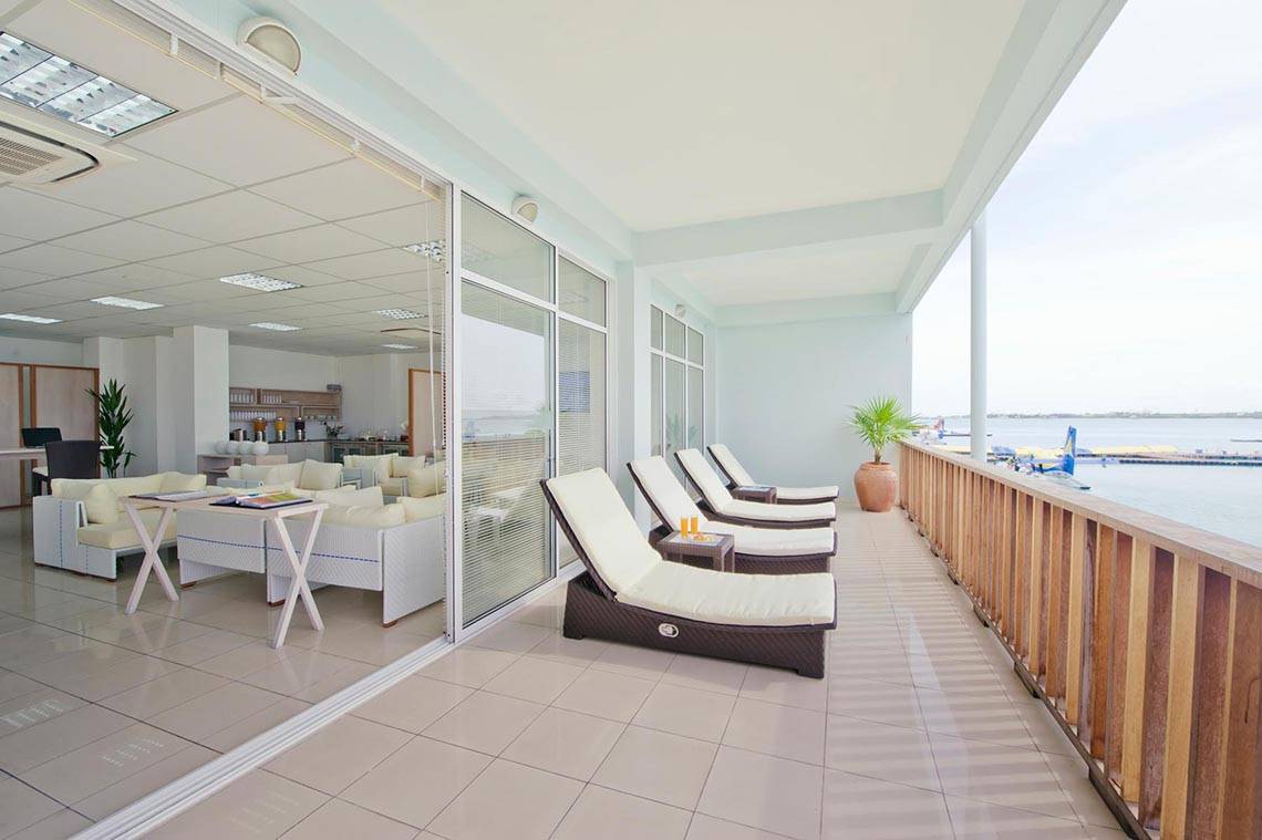 Blick auf den Balkon des Kuramathi Maldives Hotels mit Lounge-Sesseln und Meersicht.