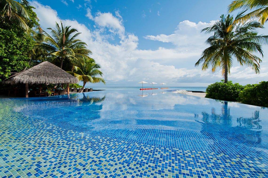 Unendlicher Pool mit Blick auf das Meer und Palmen am Kuramathi Maldives