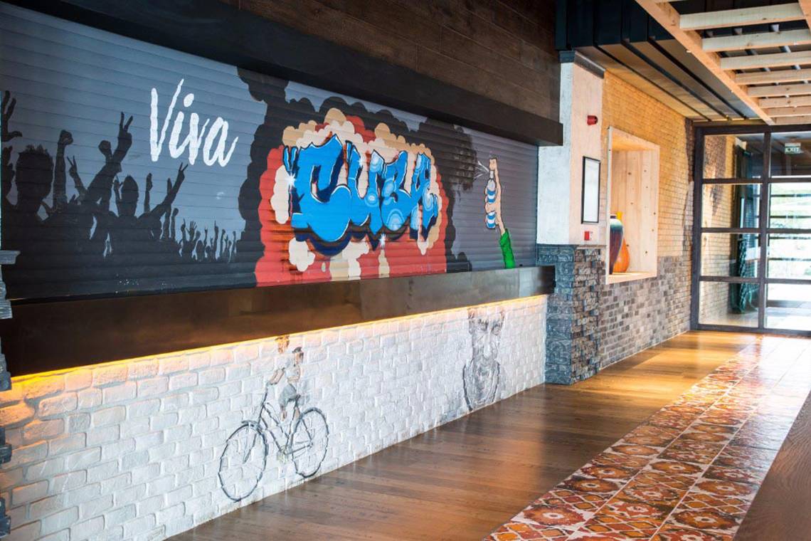 Innenbereich des Akra Hotels mit Wandgestaltung, die Viva Bush und eine Fahrradmalerei zeigt.