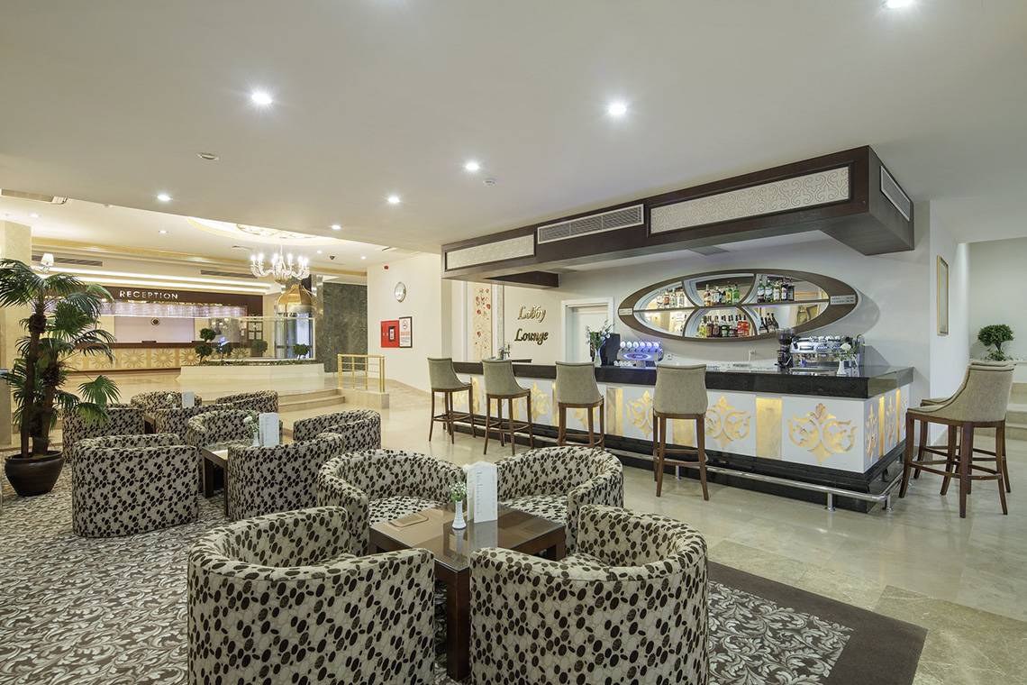 Lobby-Bar im Crystal Tat Beach Golf Resort & Spa mit geschwungenen Möbeln und einer Theke.