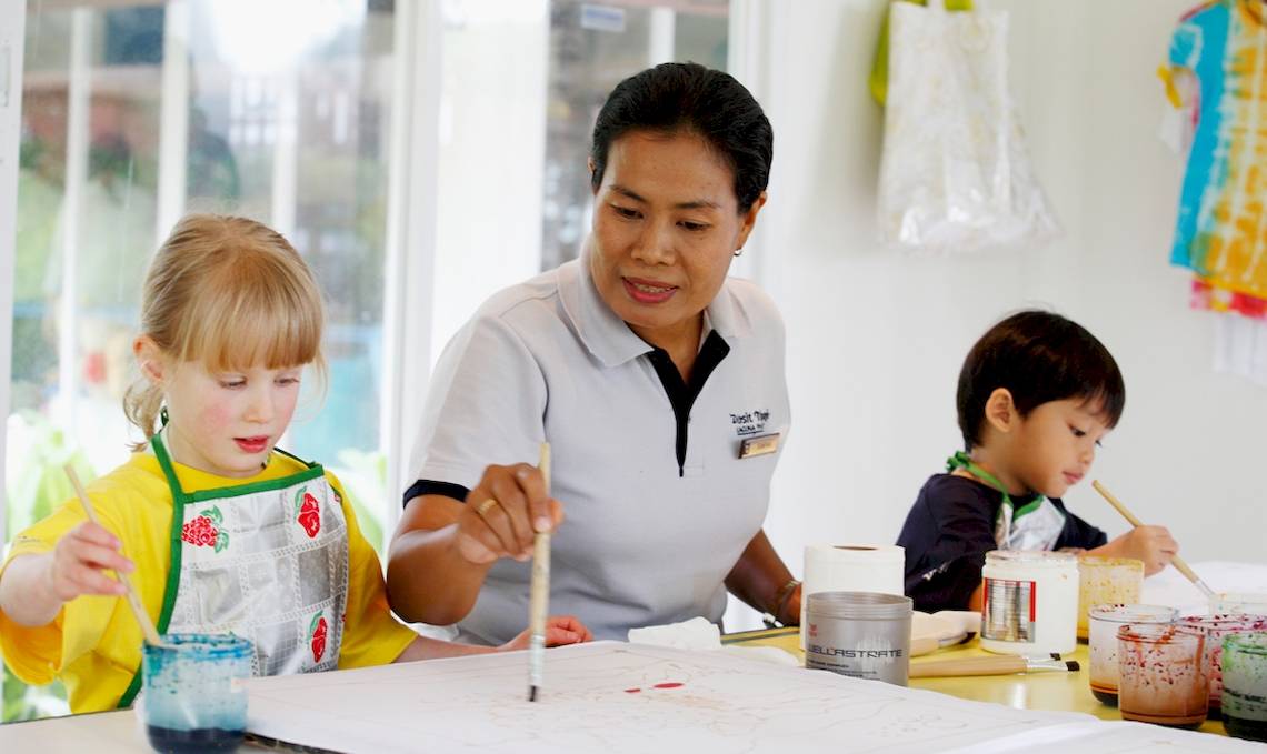 Eine Frau und zwei Kinder malen in einem Raum des Dusit Thani Laguna Phuket.