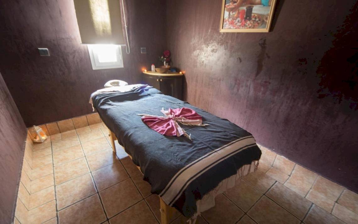 Massageraum im Green Palm Hotel mit einem Behandlungstisch und einem Kerzenlicht.