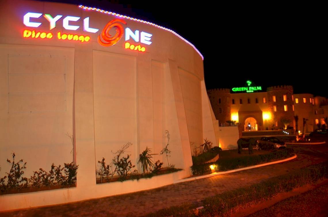 Die Außenansicht der Cyclone Disco Lounge vor dem Green Palm Hotel bei Nacht.