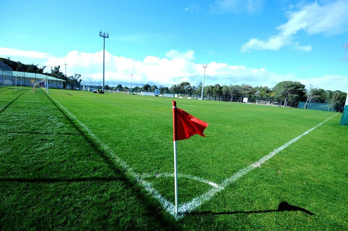 Ein leerer Fußballplatz mit einer roten Fahne an der Ecke.
