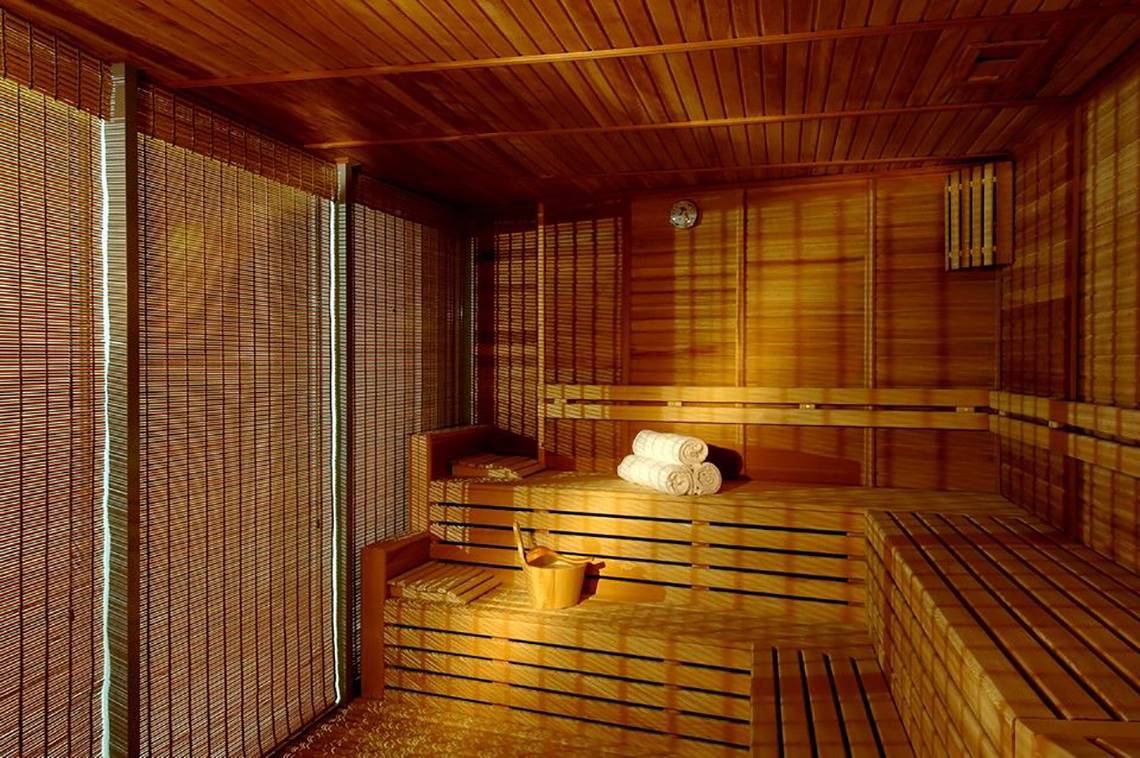 Sauna im Calista Luxury Resort mit Holzbänken und Handtuchrollen.