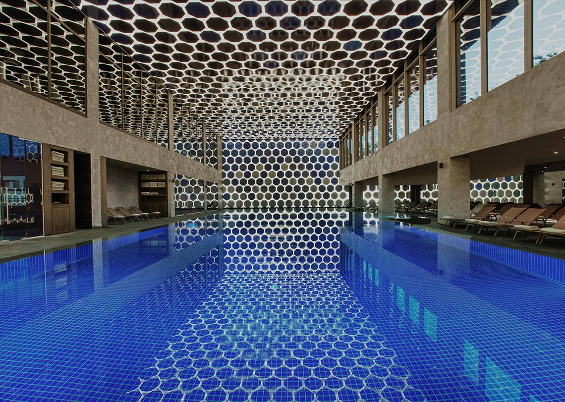 Innenpool im Maxx Royal Kemer Resort mit blauer Fliesendecke und geometrischem Muster.