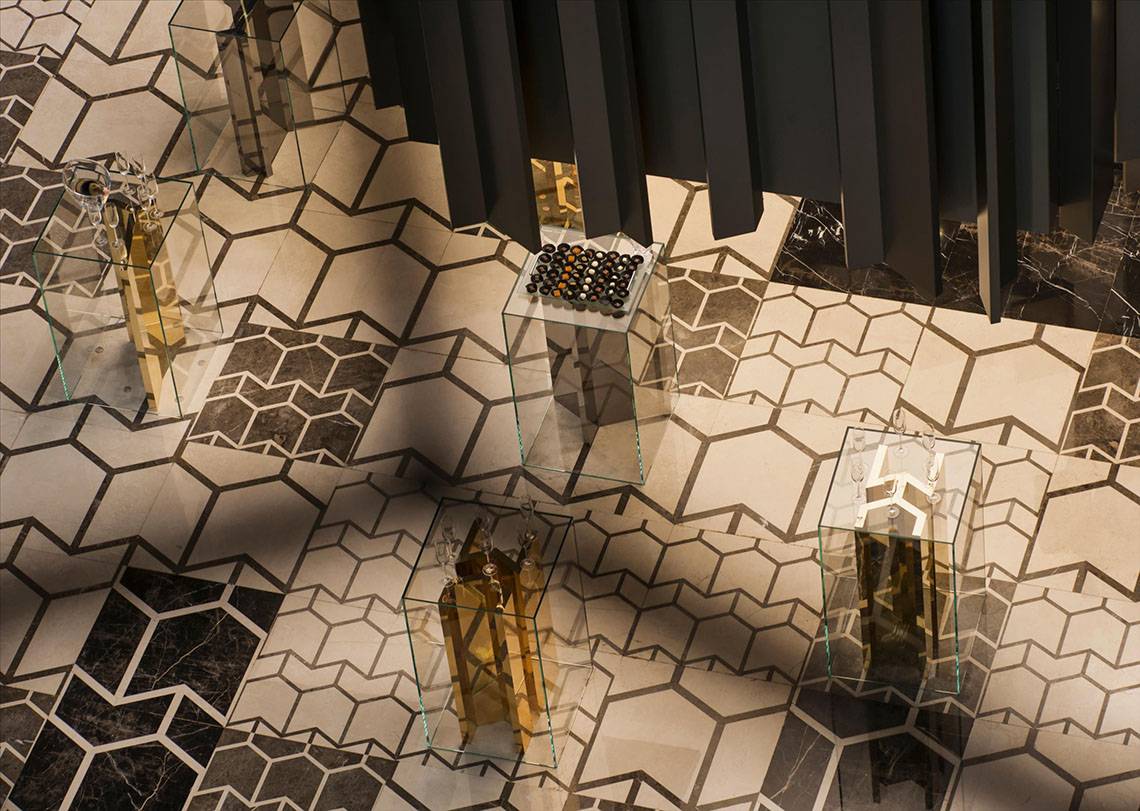 Eine Bodengestaltung des Maxx Royal Kemer Resorts mit Glastischen und Hexagonfliesen.