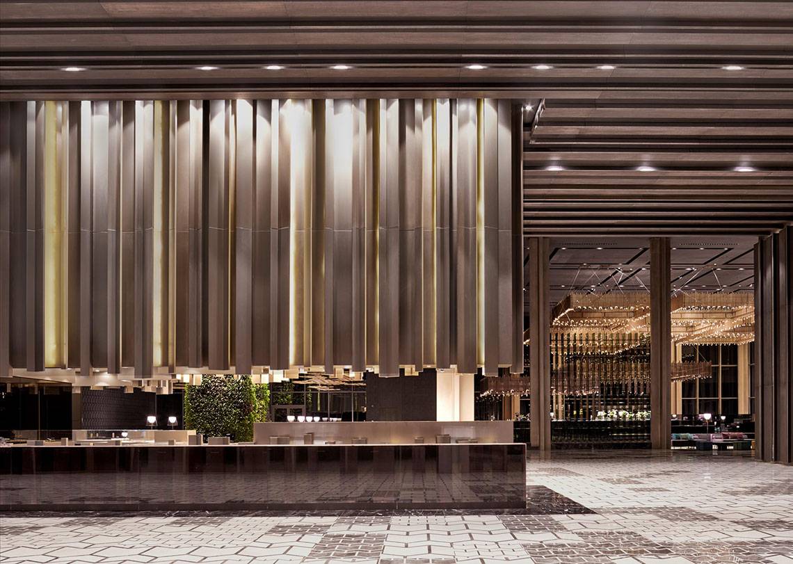 Lobby des Maxx Royal Kemer Resorts mit großen goldenen Vorhängen und moderner Einrichtung.