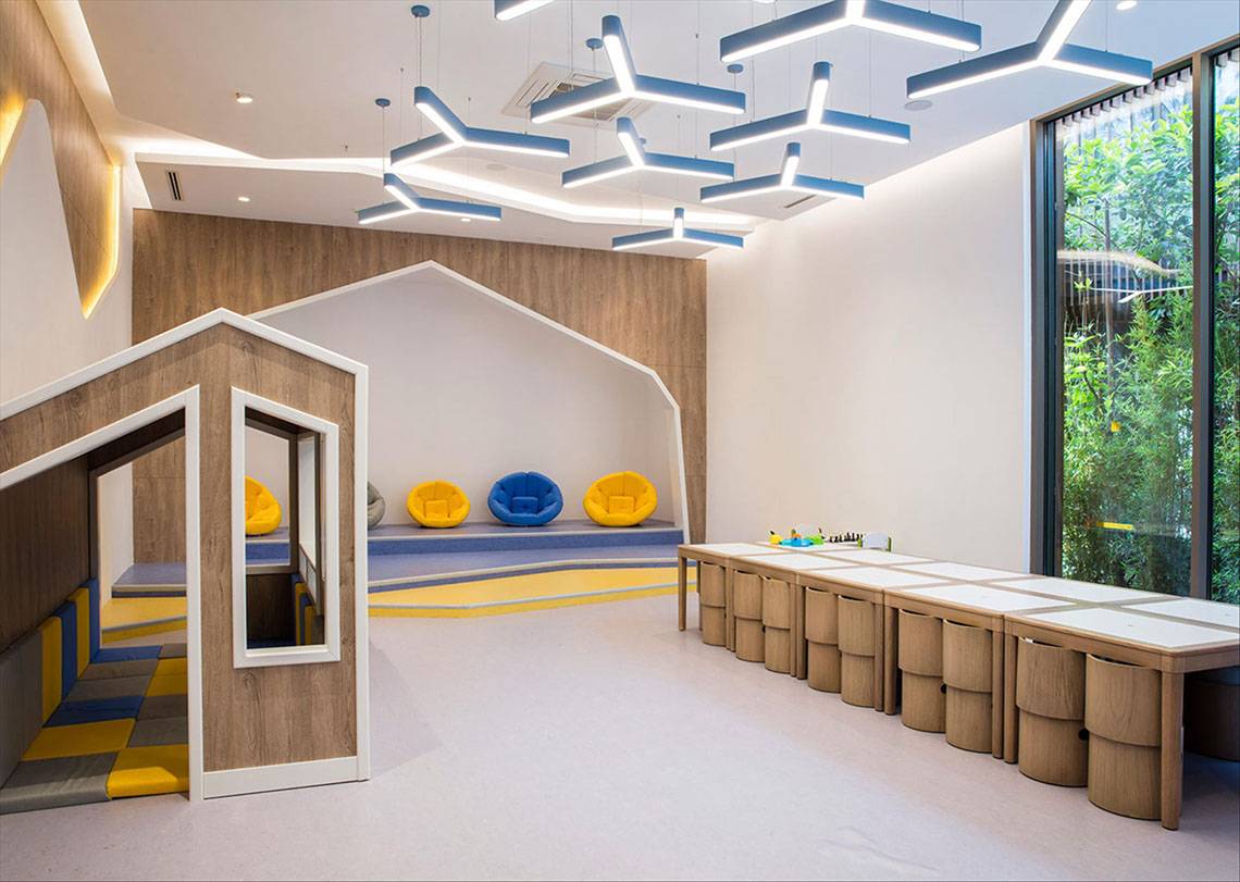 Kinderzimmer im Maxx Royal Kemer Resort mit Holzmöbeln, bunten Kissen und geometrischen Mustern.