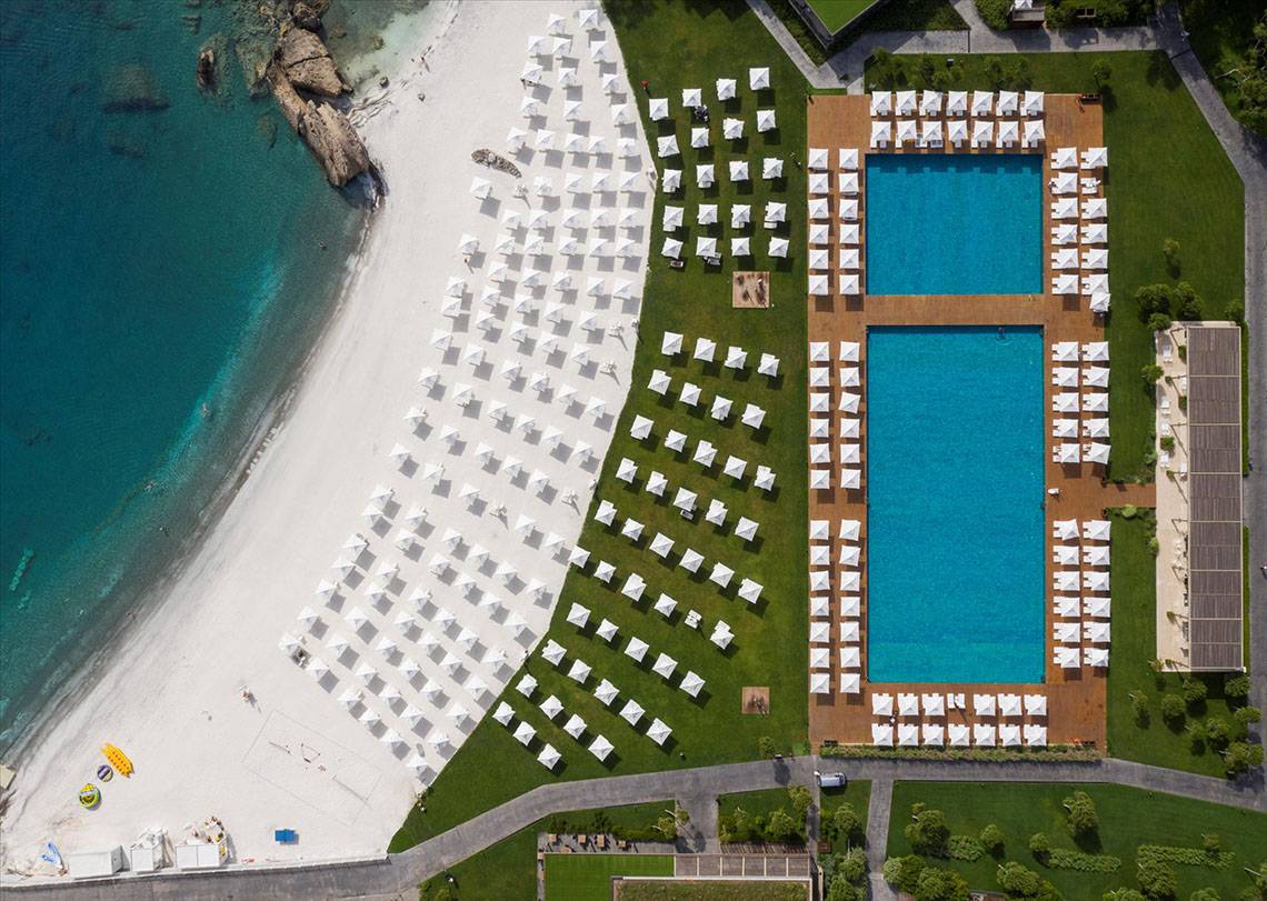 Luftaufnahme des Maxx Royal Kemer Resorts mit zwei Swimmingpools und vielen weißen Sonnenschirmen.