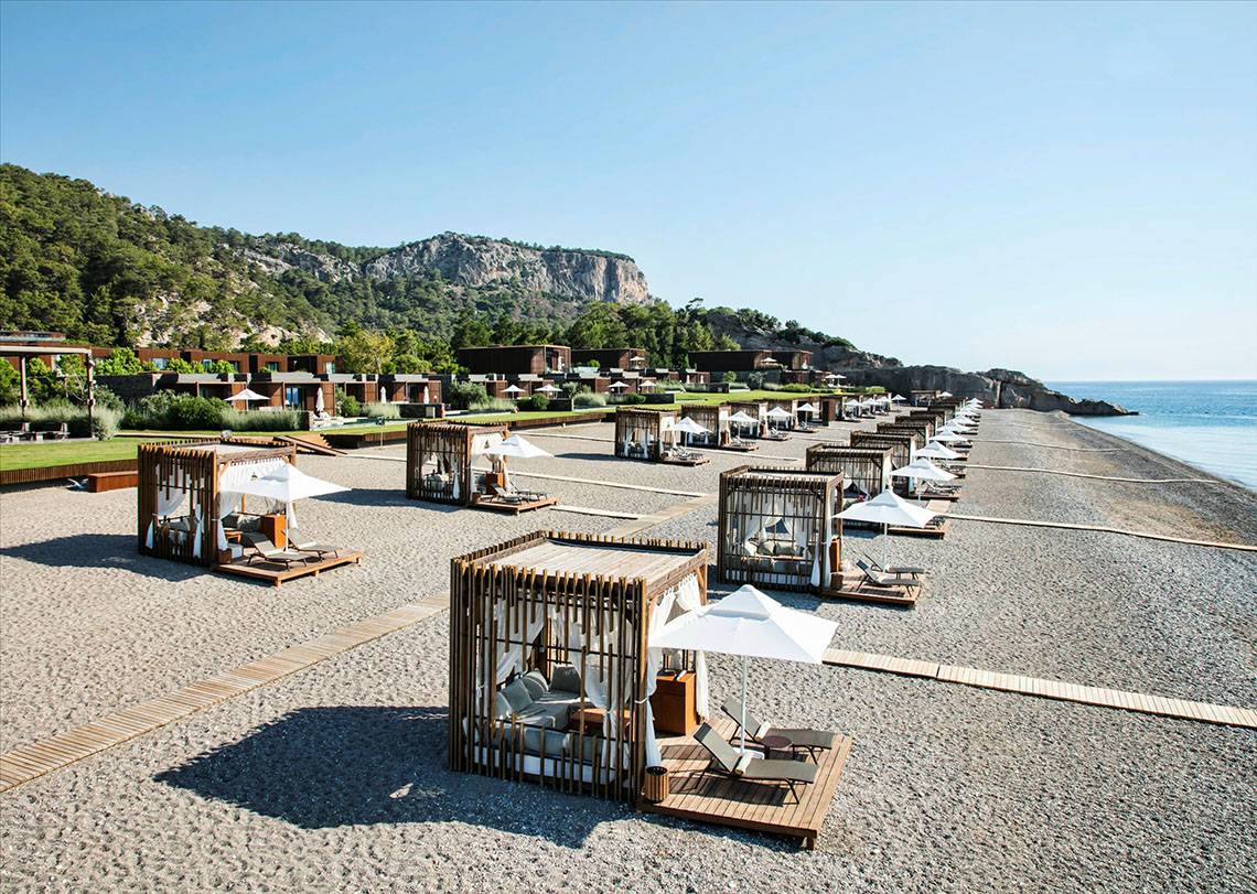 Strandlounge-Bereich im Maxx Royal Kemer Resort mit vielen Liegen und Sonnenschirmen.