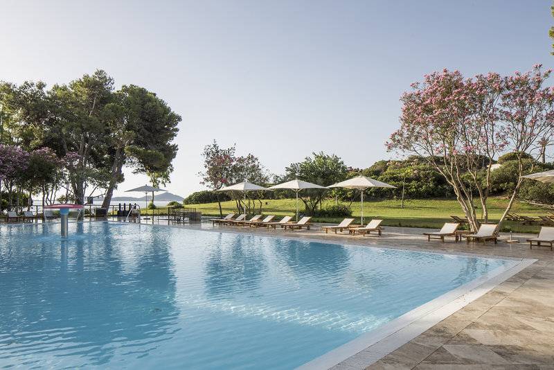 Poolbereich im Falkensteiner Resort Capo Boi mit Sonnenliegen und Schirmen