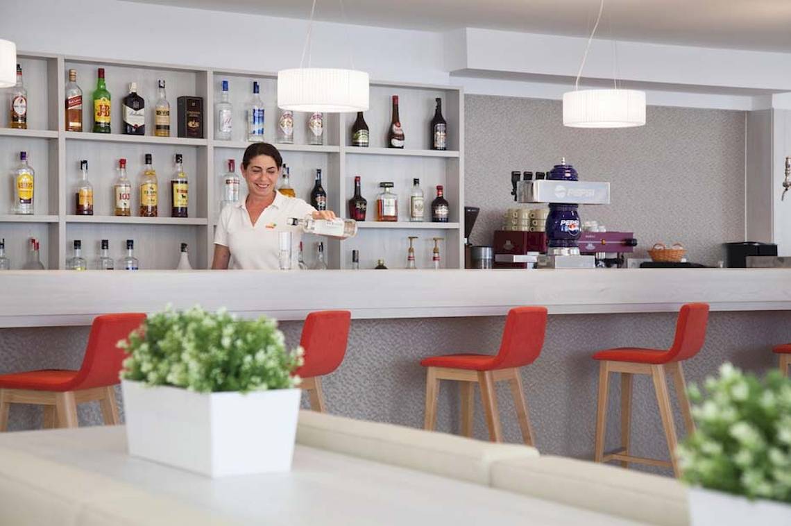 Eine Mitarbeiterin des HSM Venus Playa Hotels serviert Getränke an der Bar.
