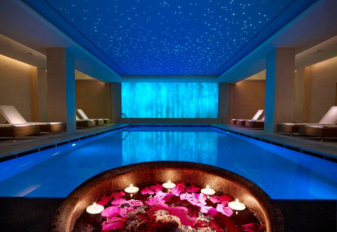 Innenpool des Astir Odysseus Kos Resort & Spa mit Sternenhimmel und Blumenkerzen