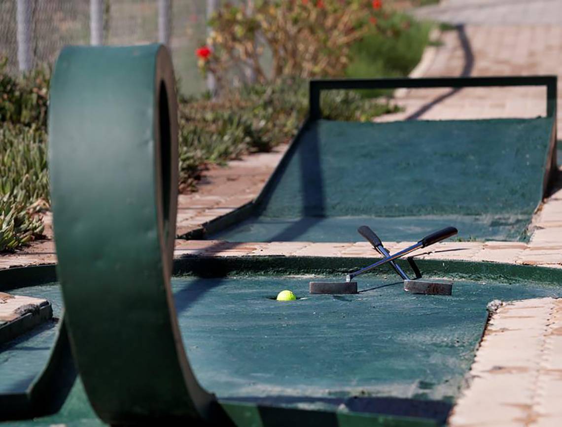Minigolfkurs im Blue Bay Resort mit einem Ball und Schlägern auf dem Grün.